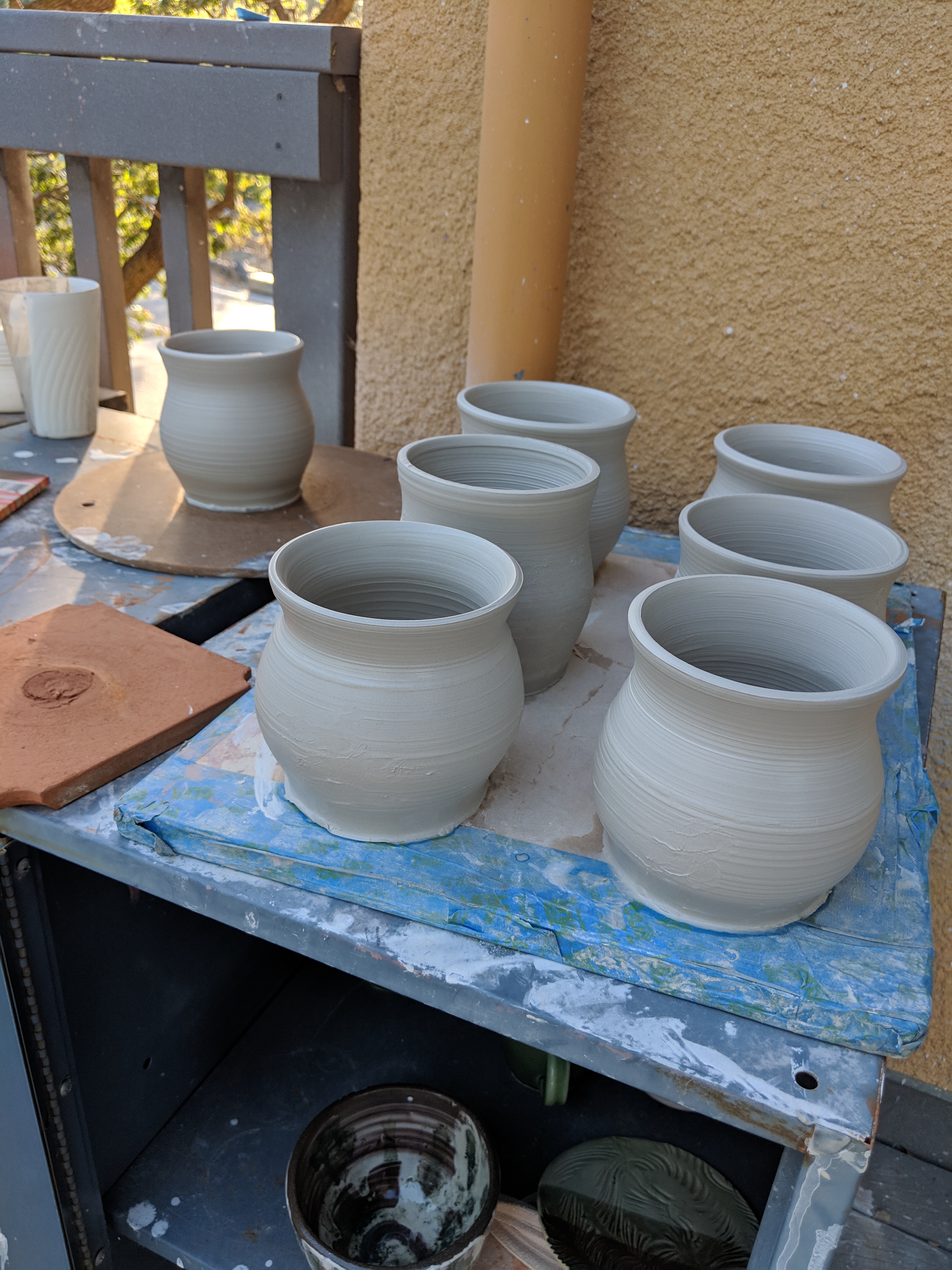 Ceramic mugs left to dry after throwing on the wheel