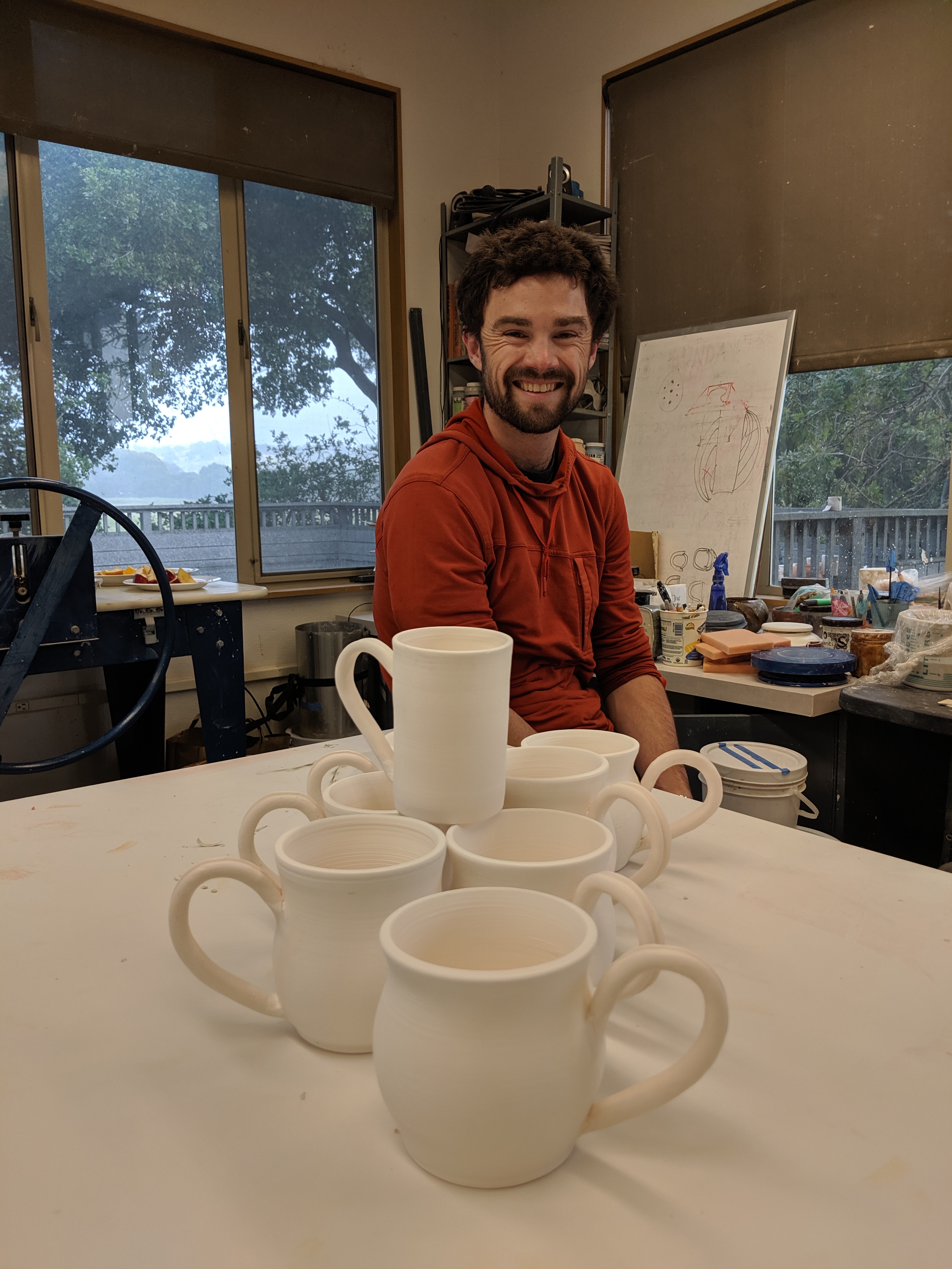 Paul Summers and bisque fired mugs waiting to be glazed