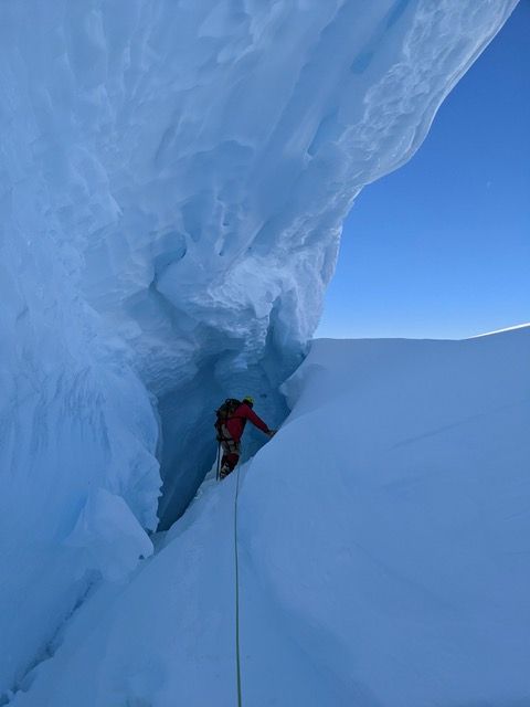 A person walks down into a ice cave