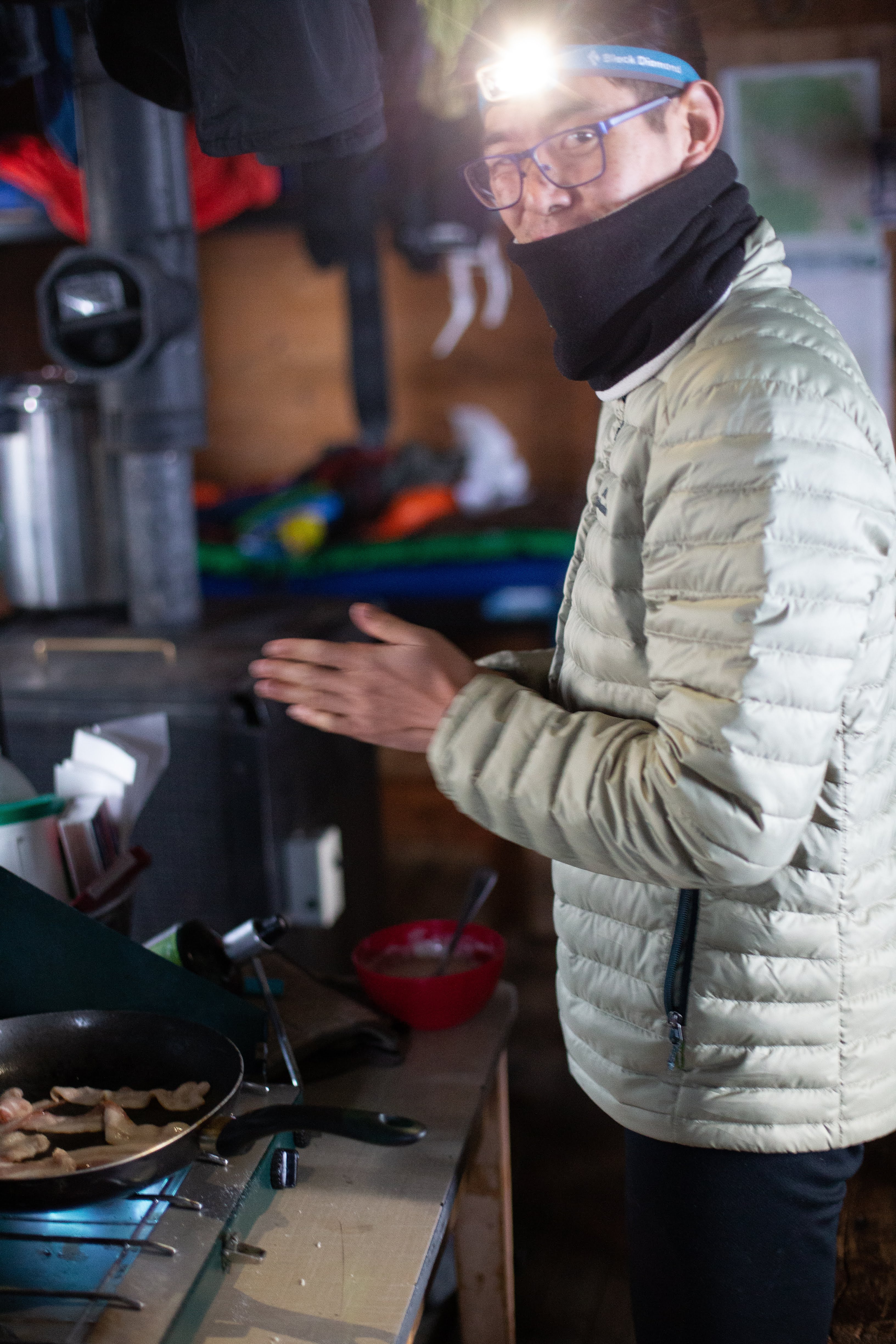 A person cooks bacon in the hut