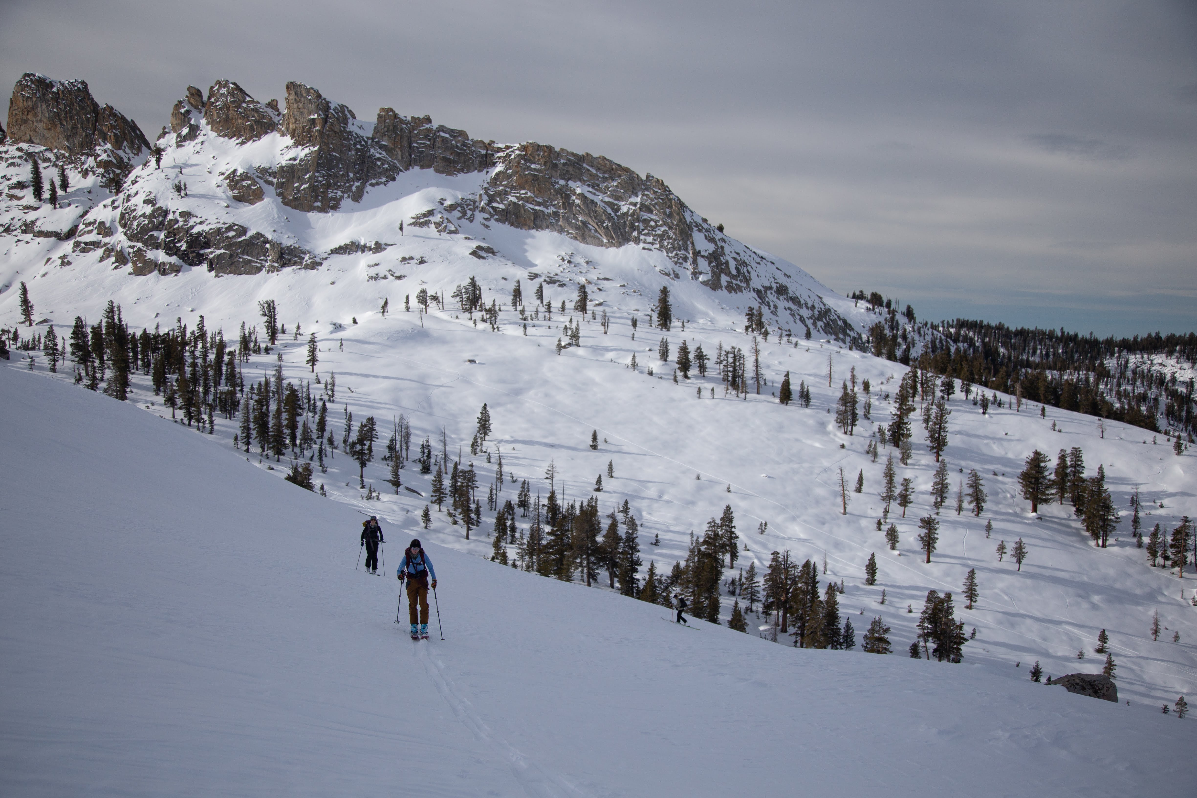 Two skiers climb away from the hut